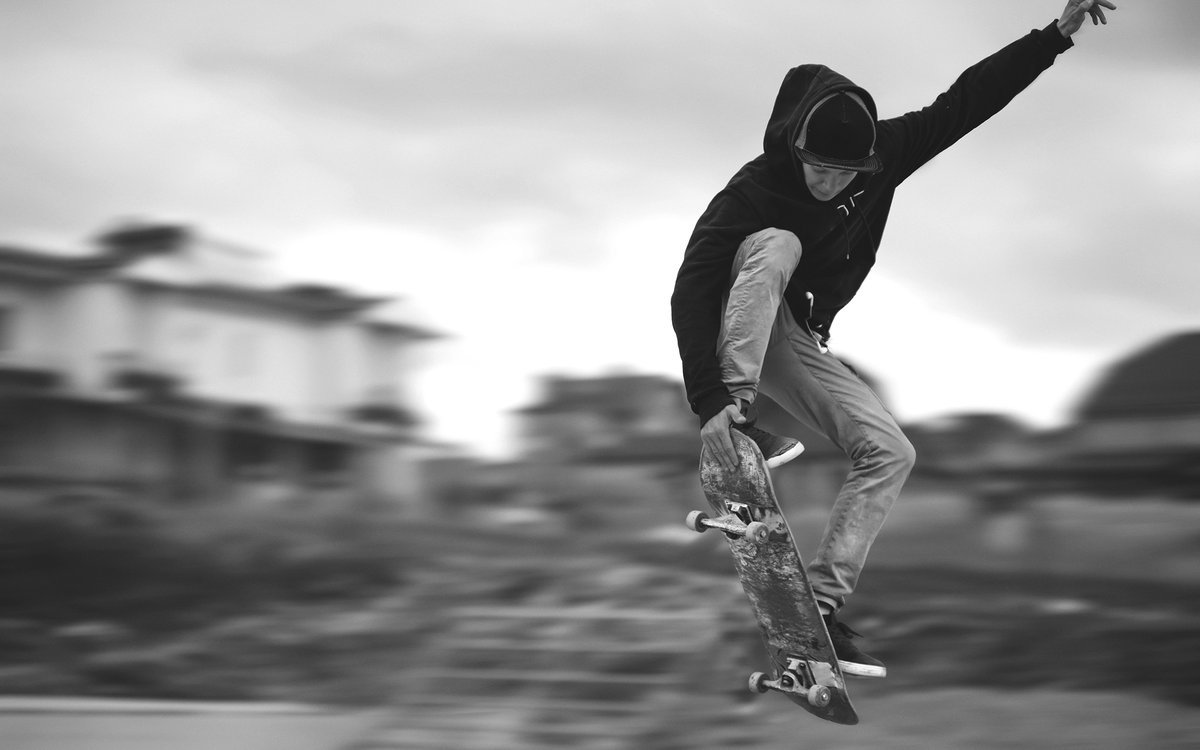 Ein Jugendlicher macht auf einem Skateboard ein Kunststück in der Luft.